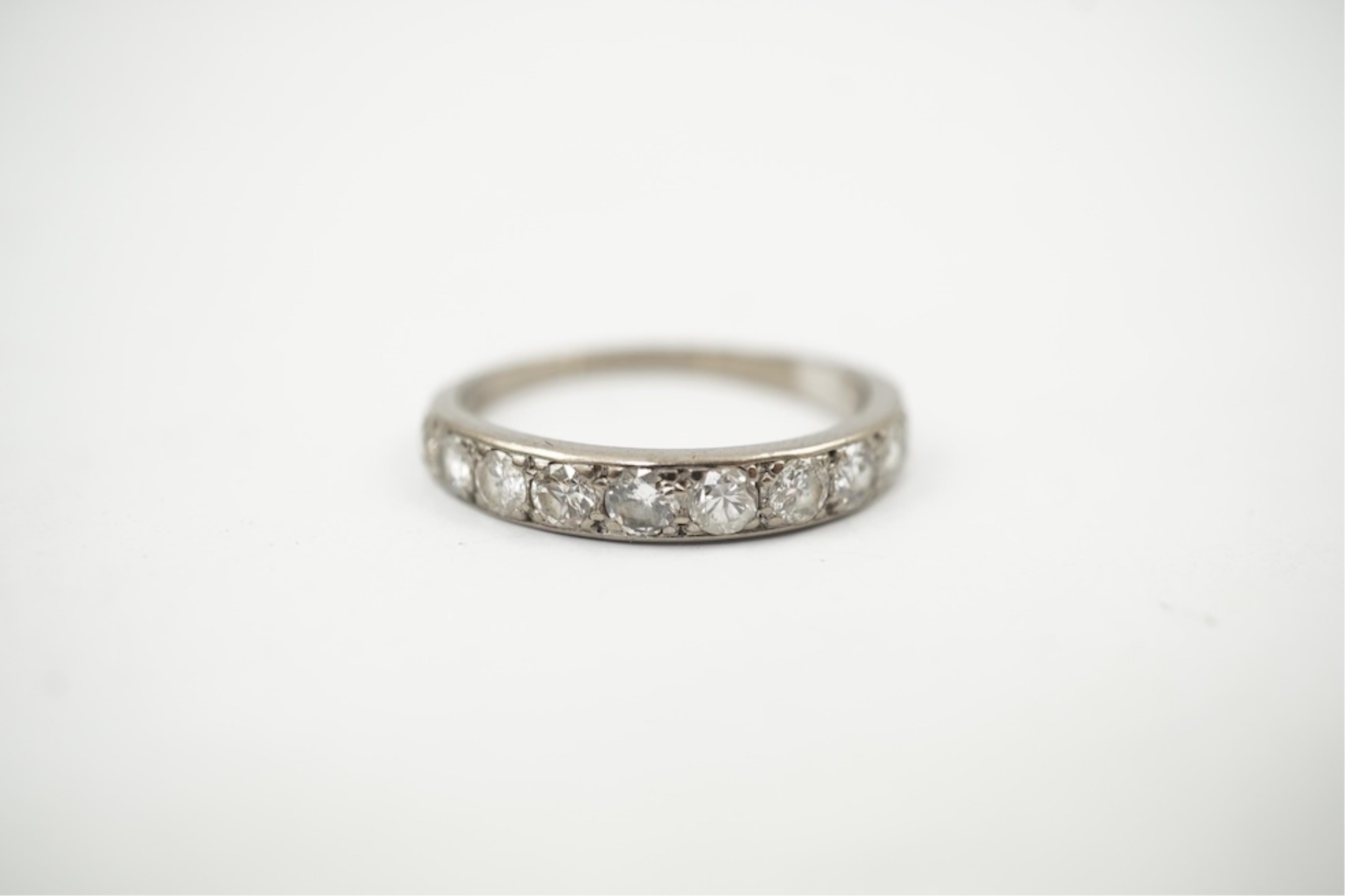 An 18ct white metal and graduated eleven stone diamond set half eternity ring, size P/Q. gross weight 3 grams.